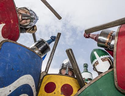 view from ground up as knights with sheids look down into the camera.