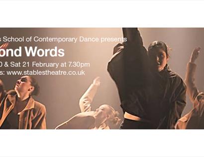 Contemporary dancers performing onstage in dramatic lighting beside text promoting the show ‘Beyond Words’.