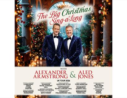 Festive Christmas concert poster with performers on stage, trees, candles, and “The Big Christmas Sing-a-Long” title.