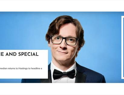 Promotional image for a comedy show at White Rock Hastings, featuring a suited performer on a blue background with event text