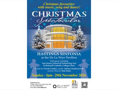 Christmas Spectacular poster with snowy De La Warr Pavilion, lit trees and event details for Hastings Sinfonia concert.