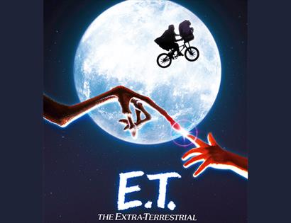 Promotional image for E.T. The Extra-Terrestrial showing a bicycle flying across the moon and touching fingertips.