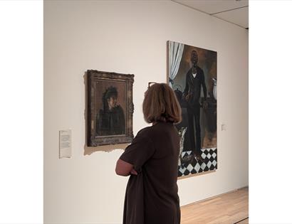 Visitor viewing paintings during a relaxed morning exhibition visit at De La Warr Pavilion gallery.