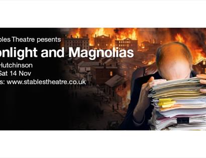 Poster for “Moonlight and Magnolias” featuring a person buried in paperwork against a backdrop of a city fire.