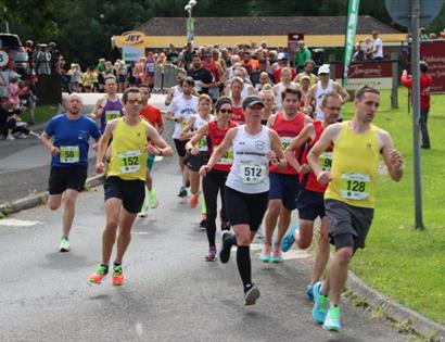 Runners take part in the Rye Half Marathon and 10K, racing along a road lined with spectators