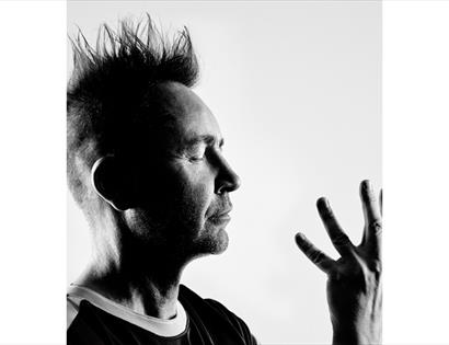 Black-and-white portrait promoting Nigel Kennedy at De La Warr Pavilion, shown in profile.