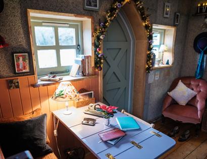Cosy Christmas reading retreat at Starcroft Farm Cabins, featuring a warm festive cabin with books, fairy lights and comfy seating.