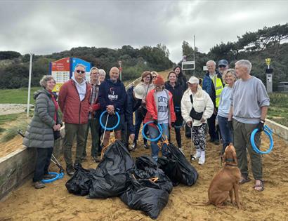 Group at The Gallivant’s Community Beach Clean holding litter pickers and bags filled with collected rubbish.