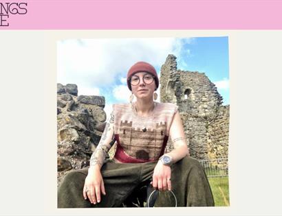 Promotional image for Beyond the Battle History Tours, showing a guide seated beside the ruins of Hastings Castle.