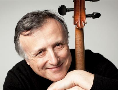 Cellist leaning beside a cello, promoting the Tea Concert: Schubert Quintet.