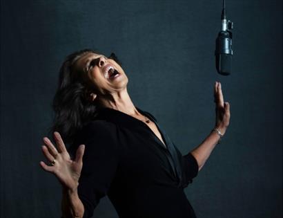Elkie Brooks singing with raised hands beside a studio microphone, promoting a live show at the DLWP.