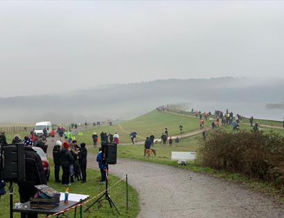 Participants and spectators line the route during the Bewl New Year 10K & 5K beside Bewl Water on a misty winter day
