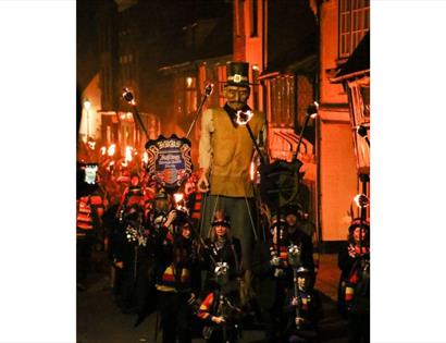Image shows the parade at Hastings Bonfire. The parade is full of bonfire society members with an effigy.