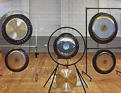 A photograph of five gong instruments in a studio.