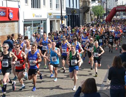 A photograph of a crowd of runners running down a Hastings street.