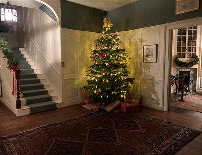 panelled hallway with christmas tree glowing