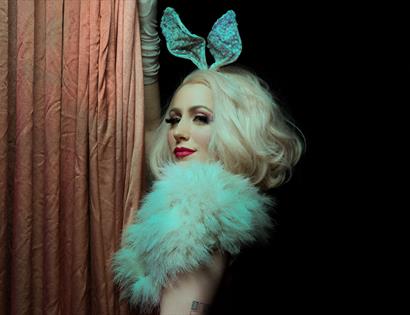 A photograph of a burlesque performer, with blonde hair and bunny ears. For an event at St Mary in the Castle Hastings