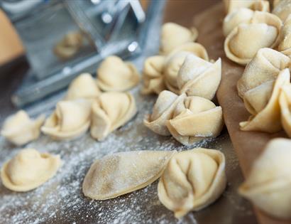 small pasta parcels on prep surface with scattered flour.