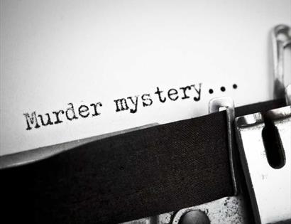 typewriter with text saying 'murder mystery'..