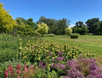 wide flower border with lawn at michelham priory.