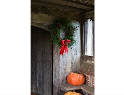 wreath and pumpkins in old timber doorway
