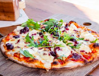 a photograph of a pizza on a wooden chopping board