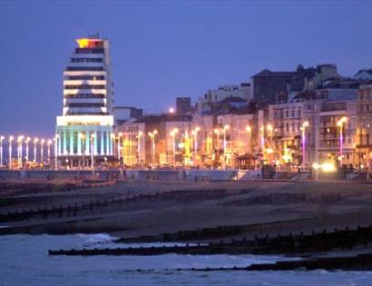 a photograph of st leonards seafront with large art deco building and promenade street lamps in twilight.