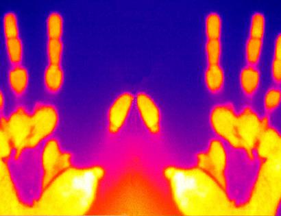 colour thermal image with yellow hands against pink and purple background.