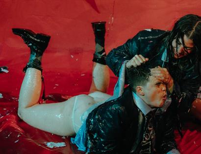 Promotional image for 50 Ways to Kill a Slug at The Stables, featuring performers in a chaotic, splash-filled scene.