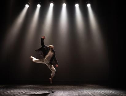 dancer leaping on a spotlit stage