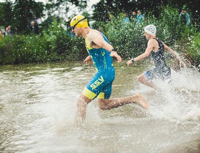 man running into lake with water splashing