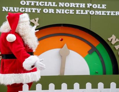 Father Christmas stood by a large gauge marked at each end as naughty and nice.