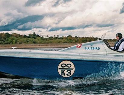 blue and silver power boat with driver, says 'bluebird' and 'k3'.