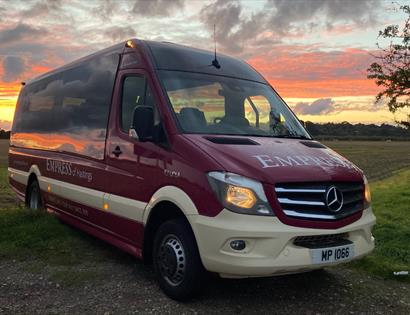 Empress Coach vehicle (mini bus) pictured in front of a sunset