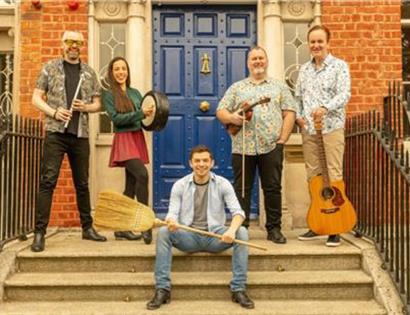 Group of five people posing on outdoor steps holding musical instruments.