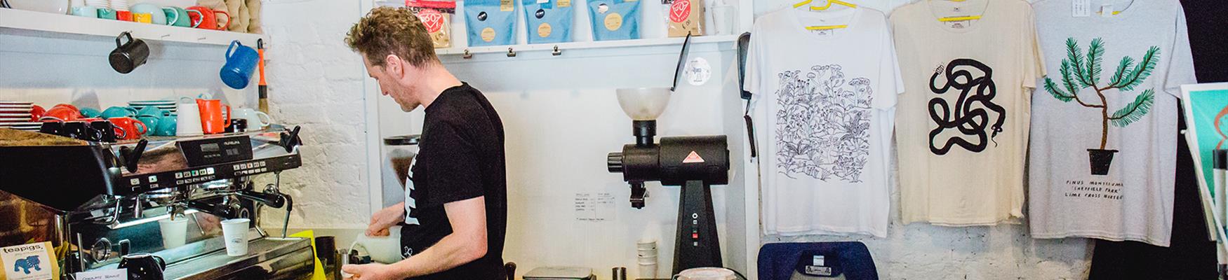 A man making coffee surrounded by items for sale at Hi-Store in Hastings' America Ground