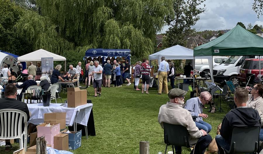 out event with small marquees on lawn and groups of people