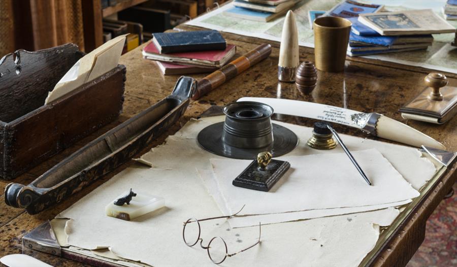 a writing desk with circular spectacles and items of stationery.