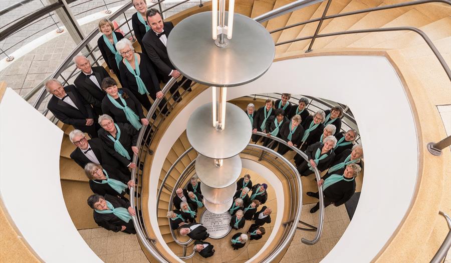 birds eye view of choir members stood around a spiral staircase.
