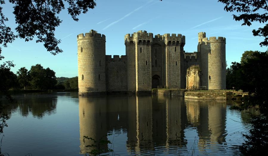 Turreted castle on large moat with reflection