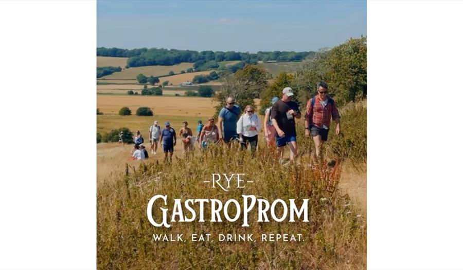 Participants walking through countryside fields during the Rye GastroProm, a food, drink and walking festival.