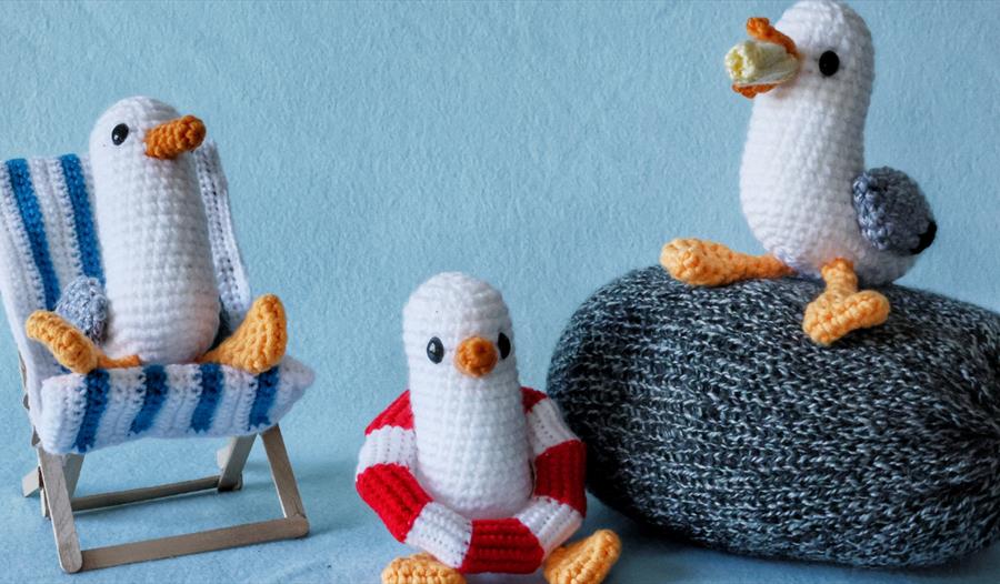 Crocheted seaside-themed seagulls with a deckchair, lifebuoy and pebble for St Michael’s Hospice Seaside Trail.