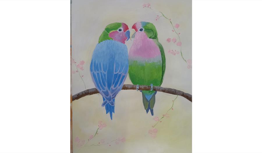 Painting of two brightly coloured lovebirds perched on a branch with soft pink blossoms.