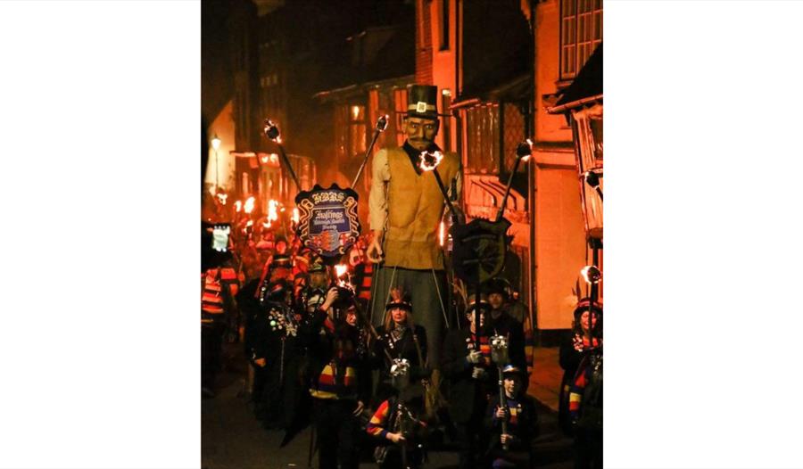 Image shows the parade at Hastings Bonfire. The parade is full of bonfire society members with an effigy.