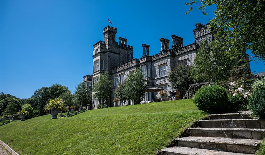 exterior of large crenellated house with grass lawn