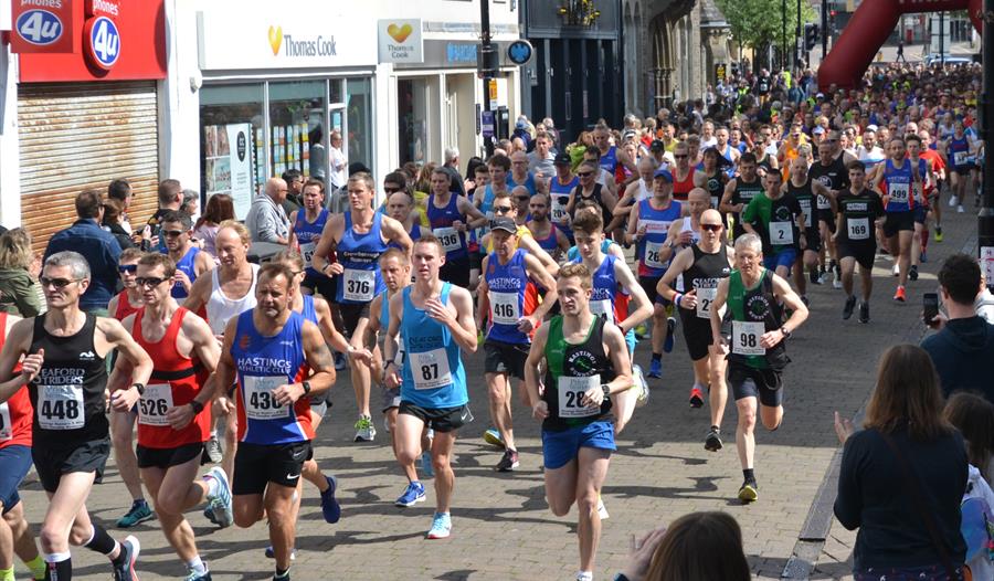 A photograph of a crowd of runners running down a Hastings street.