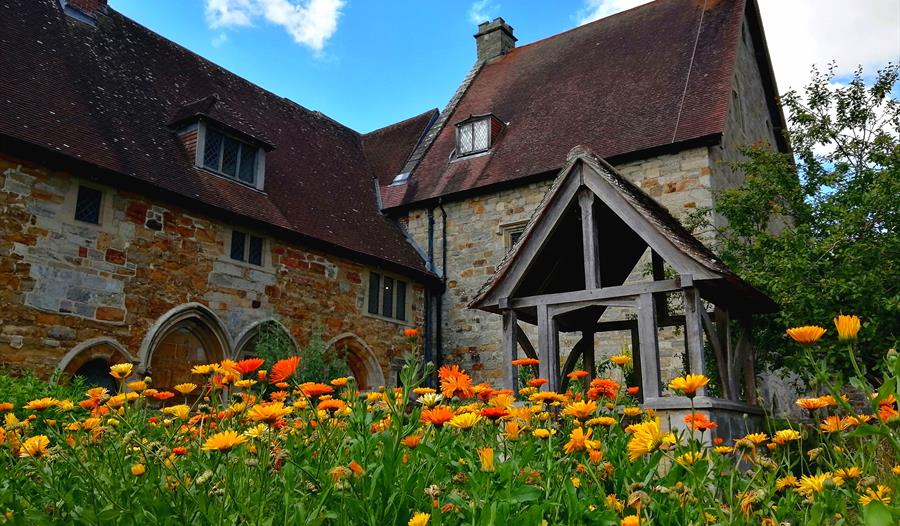 photograph of a historic stone property from a low angle with field of marigolds in the foreground.
