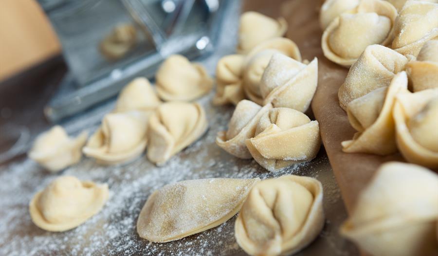 small pasta parcels on prep surface with scattered flour.