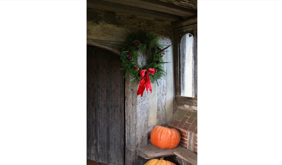 wreath and pumpkins in old timber doorway