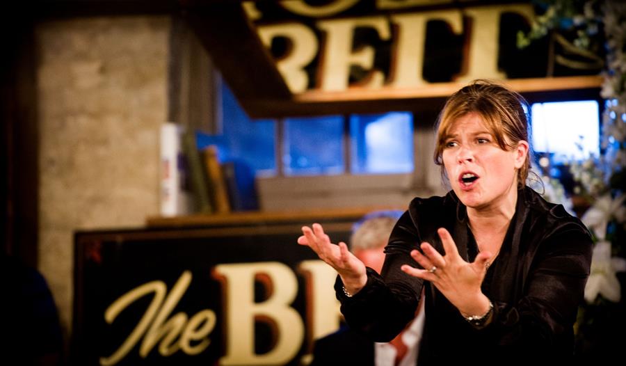 a woman presenting inside the pub